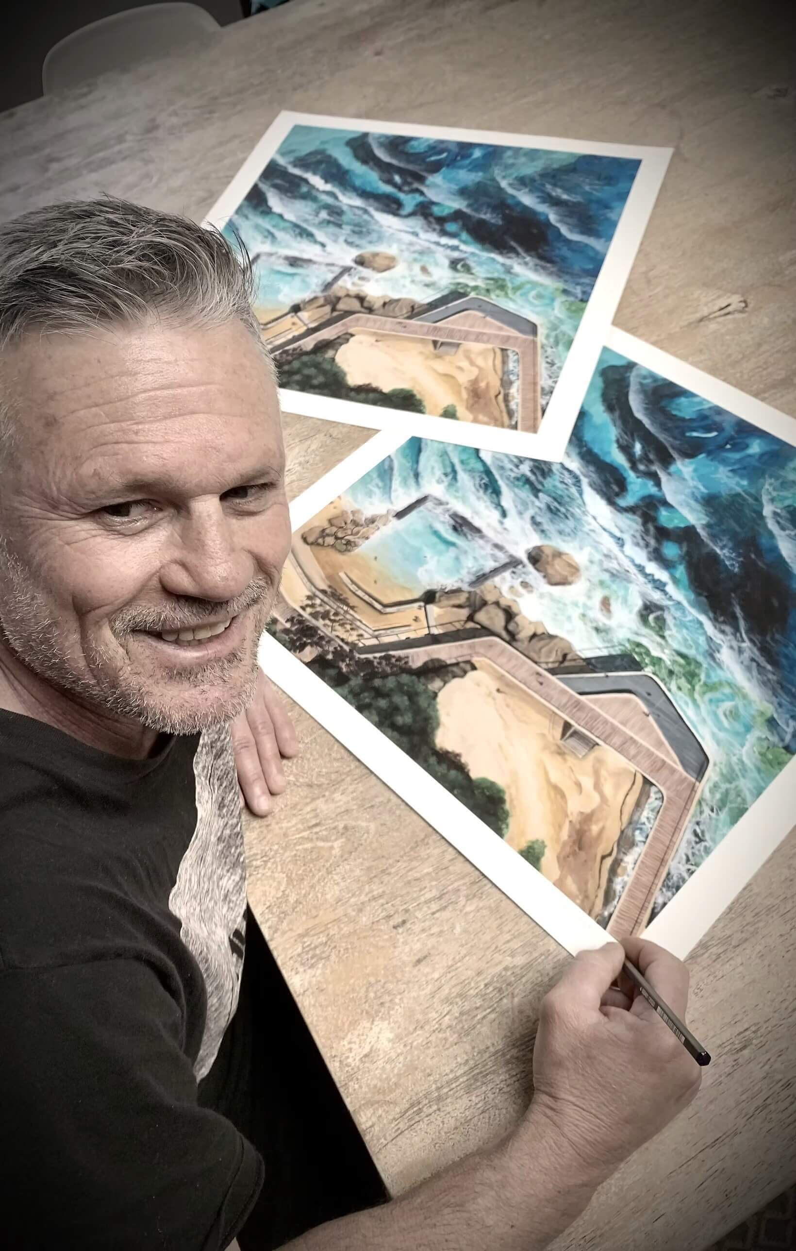 An image of a man painting on a canvas featuring the ocean and a boardwalk